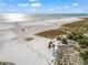 Panoramic aerial of a sandy beach with a volleyball net, palm trees, and blue ocean waters under a clear sky at 302 And 304 Canal Rd, Sarasota, FL 34242