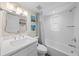 Bathroom with white tiled shower, vanity, stylish mirror, and natural light at 302 And 304 Canal Rd, Sarasota, FL 34242