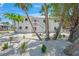 Exterior view of two-story home with exterior staircase and mature tropical landscaping at 302 And 304 Canal Rd, Sarasota, FL 34242