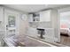 Kitchen featuring stainless steel appliances, white cabinets, backsplash and wood-look flooring at 302 And 304 Canal Rd, Sarasota, FL 34242