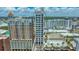 An aerial view showcases a modern high rise condo surrounded by city buildings with clear blue sky at 33 S Palm Ave # 1303, Sarasota, FL 34236