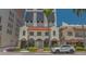 Charming building with a terracotta roof and arched windows, complemented by lush landscaping and a modern vehicle at 33 S Palm Ave # 1303, Sarasota, FL 34236