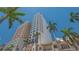 Exterior view of high rise condo building with balconies, surrounded by palm trees against a clear blue sky at 33 S Palm Ave # 1303, Sarasota, FL 34236