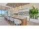 Modern kitchen with an island and bar seating, featuring sleek white cabinetry, pendant lighting, and verdant plant accents at 33 S Palm Ave # 1303, Sarasota, FL 34236