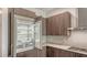Open refrigerator showcasing spacious storage alongside modern wood cabinets and a cooktop at 33 S Palm Ave # 1303, Sarasota, FL 34236