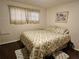 Bedroom with a tan patterned bed, dark wood floors, and tan walls with a picture at 3318 Oakwood S Blvd, Sarasota, FL 34237