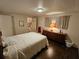 Bedroom with wood floors, a white bedspread, and a bathroom and closet view at 3318 Oakwood S Blvd, Sarasota, FL 34237
