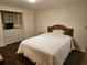 Bedroom with a white bedspread, white walls, and a wicker headboard at 3318 Oakwood S Blvd, Sarasota, FL 34237