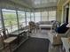 Bright Florida room with large windows, wood flooring, and cozy seating area at 3318 Oakwood S Blvd, Sarasota, FL 34237