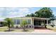 Charming single-story home featuring a covered carport, mature landscaping, and a well-maintained exterior at 3318 Oakwood S Blvd, Sarasota, FL 34237