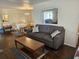 Comfortable living room with wood flooring, a sofa, and a dining room in the background at 3318 Oakwood S Blvd, Sarasota, FL 34237