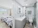 Bathroom featuring a modern vanity, illuminated mirror, and walk-in shower adjacent to bedroom at 3320 Gulf Of Mexico Dr # 208C, Longboat Key, FL 34228