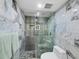 Contemporary bathroom with marble tile, a glass-enclosed shower, and modern fixtures at 3320 Gulf Of Mexico Dr # 208C, Longboat Key, FL 34228