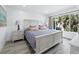 Bright bedroom featuring a large window and a comfortable bed with stylish bedding and decorative pillows at 3320 Gulf Of Mexico Dr # 208C, Longboat Key, FL 34228