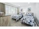 Bright and airy bedroom with twin beds, stylish decor, and natural light from large window at 3320 Gulf Of Mexico Dr # 208C, Longboat Key, FL 34228