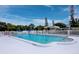 A well-maintained community pool area, surrounded by lush landscaping and comfortable lounge seating at 3320 Gulf Of Mexico Dr # 208C, Longboat Key, FL 34228