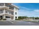 Building exterior view featuring balconies, parking, and landscaping with boats at the docks at 3320 Gulf Of Mexico Dr # 208C, Longboat Key, FL 34228