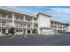 Exterior view of building showcasing balconies, parking, and a well maintained landscape at 3320 Gulf Of Mexico Dr # 208C, Longboat Key, FL 34228