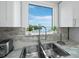 Kitchen sink with a view of boats, serene water and tropical vegetation at 3320 Gulf Of Mexico Dr # 208C, Longboat Key, FL 34228