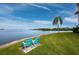 Inviting waterfront view featuring Adirondack chairs, lush lawn, and peaceful scenery at 3320 Gulf Of Mexico Dr # 208C, Longboat Key, FL 34228