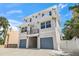 A modern two-story home with a light exterior, balcony, and a two-car garage at 340 Avenida De Mayo, Sarasota, FL 34242