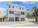 Bright two-story house with a small balcony and two-car garage, surrounded by a white fence at 340 Avenida De Mayo, Sarasota, FL 34242