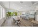 Sun-filled dining area with a large table next to a kitchen featuring a large island and white cabinetry at 340 Avenida De Mayo, Sarasota, FL 34242