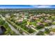 Aerial view of a beautiful home with lush landscaping in a peaceful neighborhood with a pond nearby at 385 165Th Ne Ct, Bradenton, FL 34212