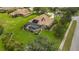 Aerial shot of a home featuring a tile roof, screened-in pool, solar panels, and a manicured lawn at 385 165Th Ne Ct, Bradenton, FL 34212