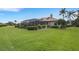 Sprawling backyard featuring lush green lawn and an enclosed lanai with beautiful landscaping at 385 165Th Ne Ct, Bradenton, FL 34212