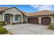 Elegant home exterior with a spacious three-car garage, a tile roof, and manicured landscaping at 385 165Th Ne Ct, Bradenton, FL 34212
