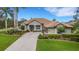 Beautiful single-story home with lush landscaping, a tile roof and a three-car garage at 385 165Th Ne Ct, Bradenton, FL 34212