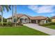 Charming single-story home with a tile roof, lush landscaping, a paver driveway and a two-car garage at 385 165Th Ne Ct, Bradenton, FL 34212
