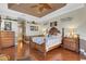 Well-lit main bedroom featuring hardwood floors, a tray ceiling, ceiling fan, and stylish furniture at 385 165Th Ne Ct, Bradenton, FL 34212