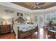 Luxurious main bedroom with a tray ceiling, ceiling fan, and French doors leading to the outdoors at 385 165Th Ne Ct, Bradenton, FL 34212