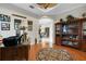 Well-lit office space featuring hardwood floors, a ceiling fan, built-in bookcase, and view into living area at 385 165Th Ne Ct, Bradenton, FL 34212