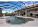 Screened-in pool area with spa, adjacent to covered patio with seating and summer kitchen at 385 165Th Ne Ct, Bradenton, FL 34212