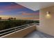 Balcony view overlooking lush greenery and a stunning beach at sunset, enhanced by a warm outdoor light at 4200 Gulf Dr # 104, Holmes Beach, FL 34217