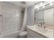 Bright bathroom featuring marble tile, a bathtub with shower, and a modern vanity with ample lighting at 4200 Gulf Dr # 104, Holmes Beach, FL 34217