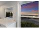 Bedroom window view showcasing a beautiful beach sunset and coastal scenery, reflecting in an adjacent mirror at 4200 Gulf Dr # 104, Holmes Beach, FL 34217