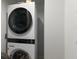 Modern stacked LG washer and dryer laundry appliance against a clean, bright white wall at 4200 Gulf Dr # 104, Holmes Beach, FL 34217