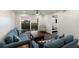 Inviting living room with comfortable blue sofas, dark wood coffee table, and sliding doors leading to a balcony with a view at 4200 Gulf Dr # 104, Holmes Beach, FL 34217