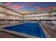 Large community pool surrounded by multi-story condo building and lounge chairs, ideal for relaxation at 4200 Gulf Dr # 104, Holmes Beach, FL 34217
