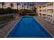 Inviting outdoor pool surrounded by palm trees and lounge chairs, perfect for relaxation with a lovely sunset at 4200 Gulf Dr # 104, Holmes Beach, FL 34217