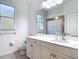 Bright bathroom featuring a white vanity with a large mirror and a window for natural light at 4239 Corso Venetia Blvd, Venice, FL 34293