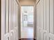 Hallway view of a bright bathroom featuring a tub, shower, and a stylish arched window at 4239 Corso Venetia Blvd, Venice, FL 34293