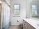 Bright bathroom featuring a shower/tub combo with white/blue curtain and a window for natural light at 4239 Corso Venetia Blvd, Venice, FL 34293