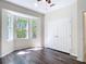 Bedroom features dark wood floors, a ceiling fan, and a large window at 4239 Corso Venetia Blvd, Venice, FL 34293