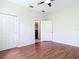 Bedroom features wood flooring, a ceiling fan, closet, and an ensuite bath at 4239 Corso Venetia Blvd, Venice, FL 34293