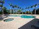 Large community pool and spa with tiled deck, clear blue water, and surrounding palm trees at 4239 Corso Venetia Blvd, Venice, FL 34293